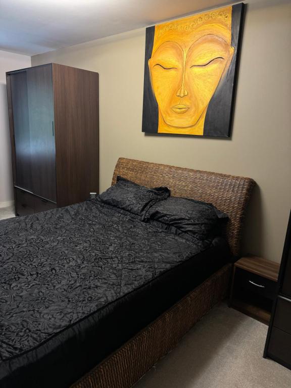 ein Schlafzimmer mit einem Bett und einem Wandgemälde in der Unterkunft Grove flat - two bedroom flat in central Dunstable in Dunstable
