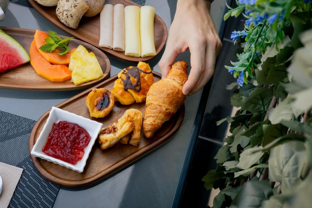 A styled breakfast spread of pastries, bread, fruit, cheese and jam.