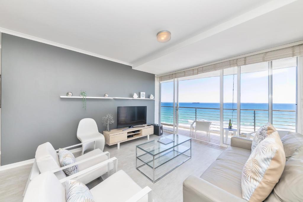 a living room with a white couch and a television at Horizon Bay 702 in Bloubergstrand