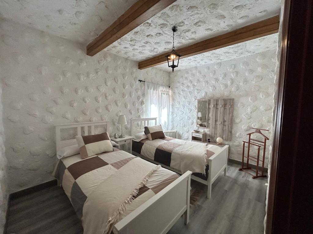 サンタクルス・デ・テネリフェにあるCasa Rural Juliの白い壁のベッドルーム1室(ベッド2台付)