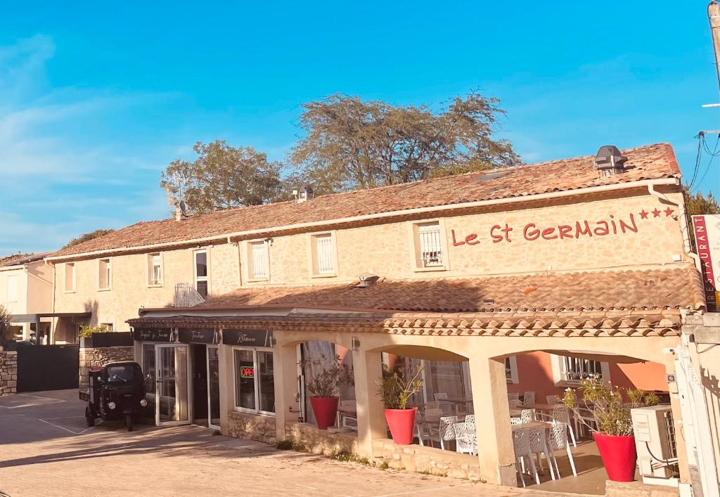 an old building with a sign on the side of it at Hotel Saint Germain in Pézenas