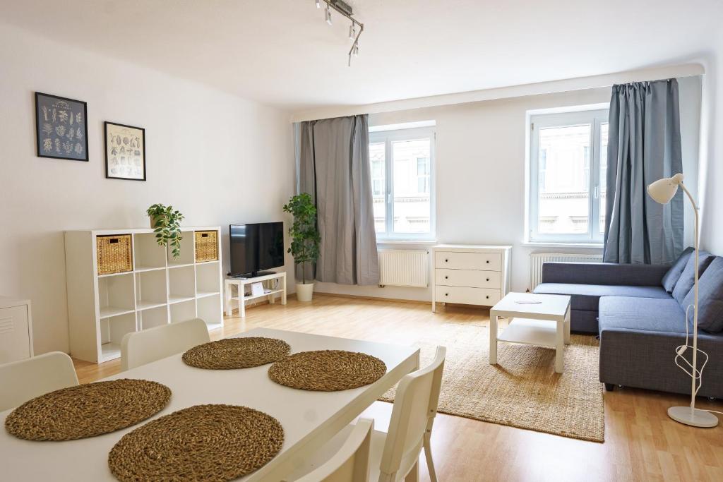 ein Wohnzimmer mit einem Tisch und einem blauen Sofa in der Unterkunft Central Living Apartments - Schottentor in Wien