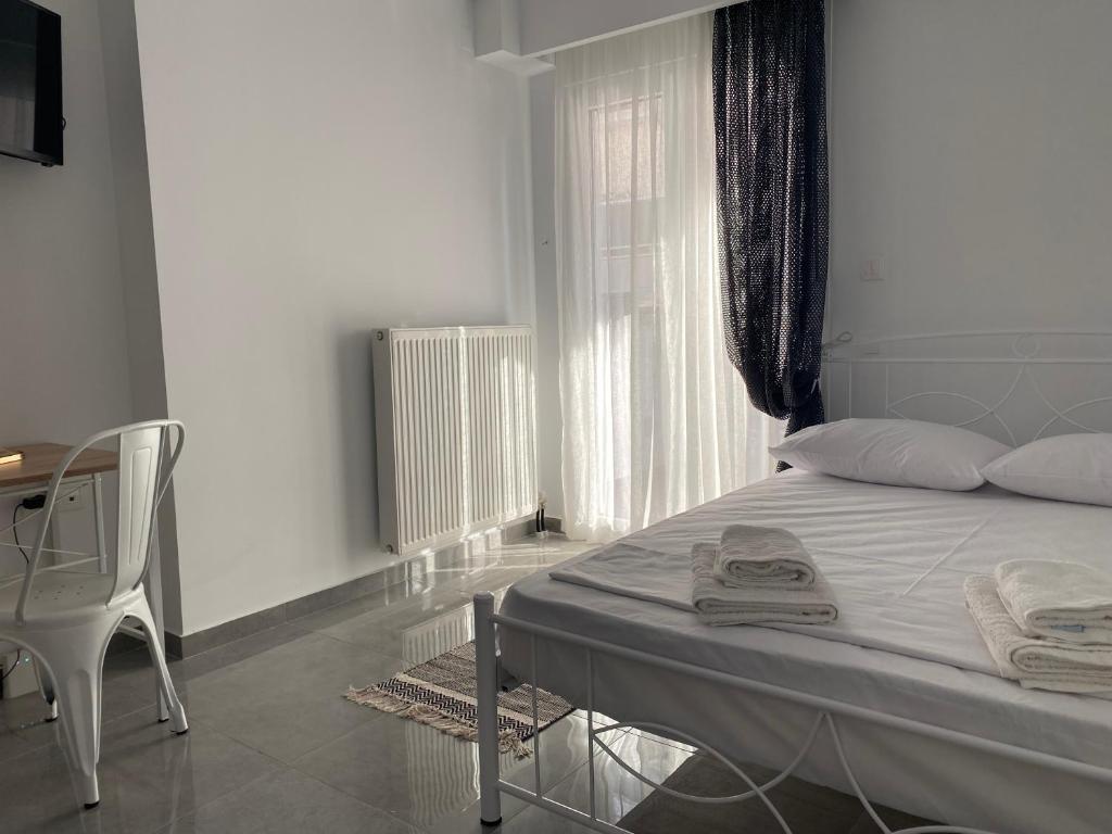 a bedroom with a bed and a desk and a window at Kinfeels' apt ( PM2 ) in Larisa