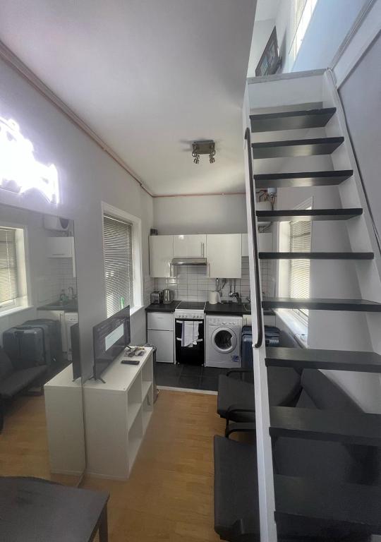 eine Küche mit einer Treppe, die in ein Wohnzimmer führt in der Unterkunft Quirky Studio Camden in London