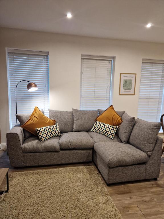 Hotel Large Jewellery Quarter Apartment - sleeps 7! NEW, a living room with a gray couch with pillows on it at Large Jewellery Quarter Apartment - sleeps 7! NEW in Birmingham