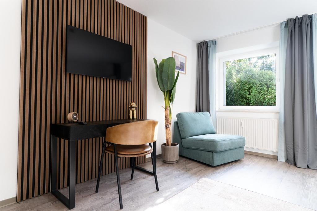 a living room with a desk and a chair at Blumenhaller Boardinghouse in Osnabrück