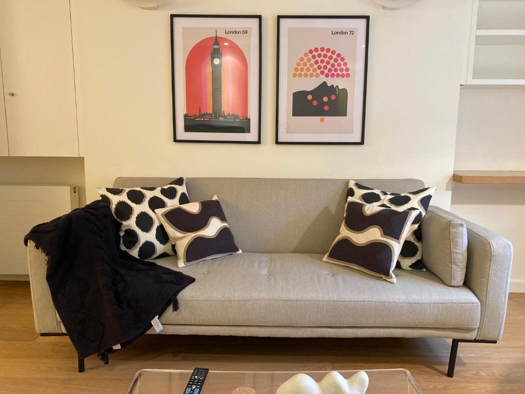 a living room with a couch and pictures on the wall at Regent’s Park / Marylebone Studio Flat in London