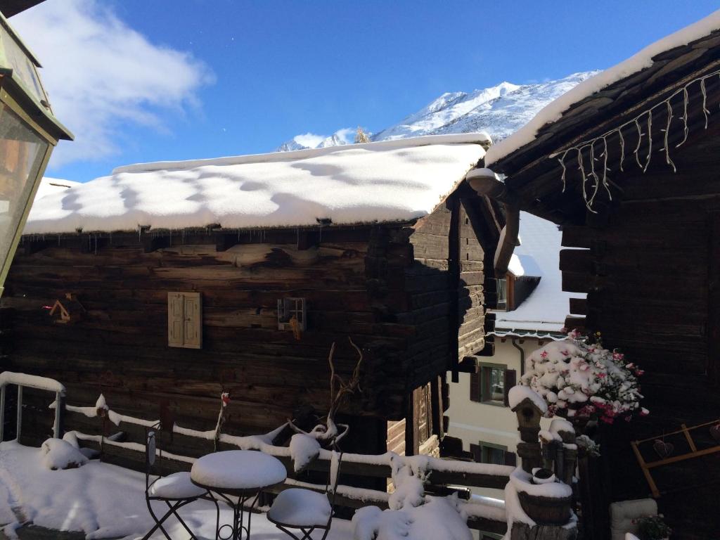 a log cabin with snow on the roof at Hotel Romantica in Zermatt