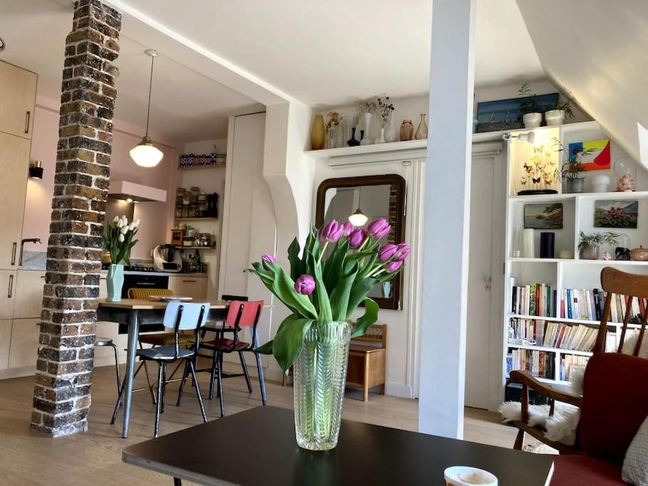 un vase de fleurs sur une table dans le salon dans l'établissement Appartement cosy dans le 9e, à Paris