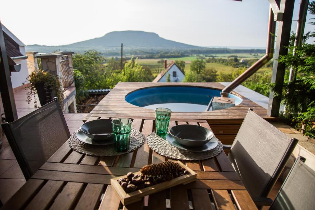 una terraza de madera con mesa, sillas y piscina en Naphoz Holddal, en Kisapáti