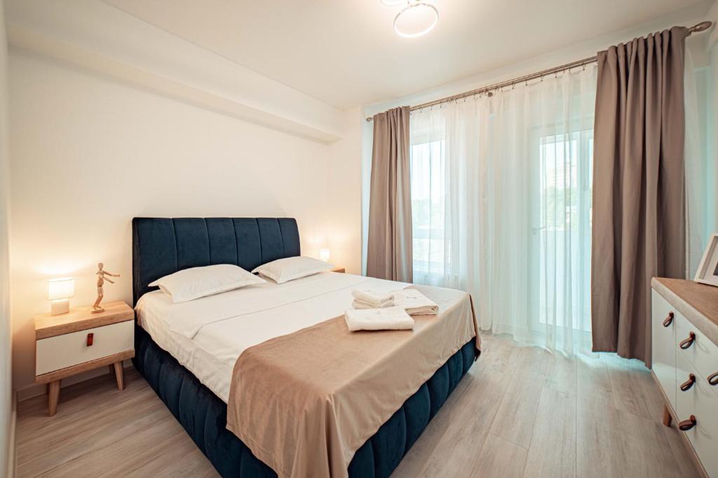 a bedroom with a large bed and a window at COZY APARTHOTEL - Ultracentral Luxury Apartments Iasi in Iaşi