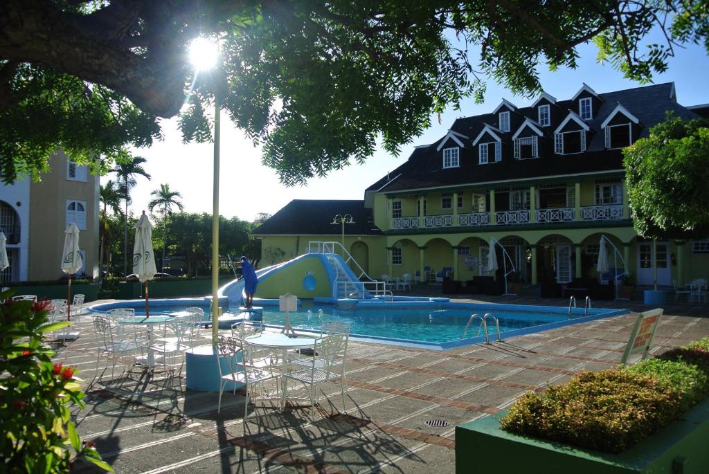 einen Pool mit Spielplatz neben einem Gebäude in der Unterkunft Beach Studio 6 in Ocho Rios