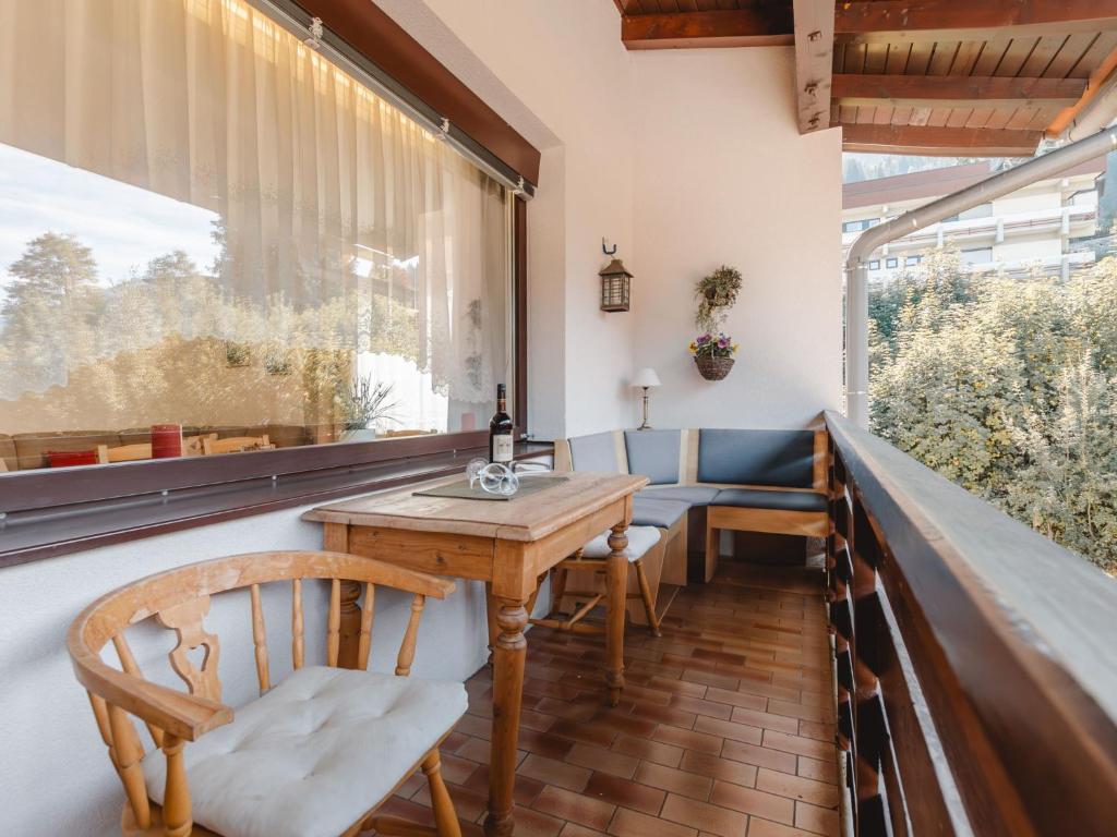 uma varanda com uma mesa e cadeiras de madeira e uma janela em Apartment Haus Reitl VII by Interhome em Bad Gastein