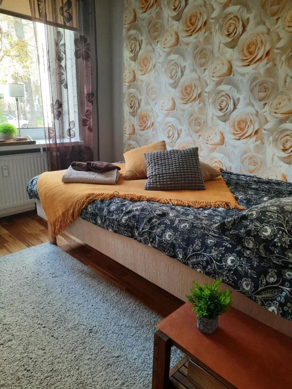 a bedroom with a bed with roses on the wall at Lennuki Apartement in Rakvere