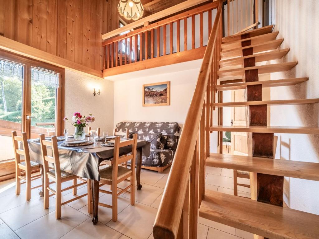 une salle à manger avec un escalier en bois, une table et des chaises dans l'établissement Apartment Le Tetras-2 by Interhome, à Morzine