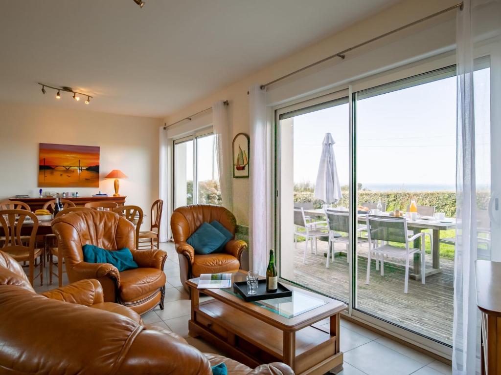 ein Wohnzimmer mit Ledermöbeln, einem Tisch und einem Esszimmer in der Unterkunft Holiday Home Mer d'Iroise 1 - LCQ104 by Interhome in Le Conquet