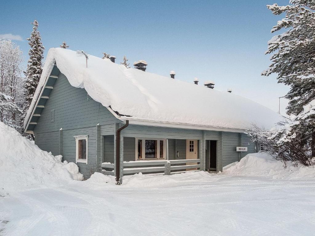 a house with snow on the roof in the snow at Holiday Home Kiehislevi a by Interhome in Sirkka