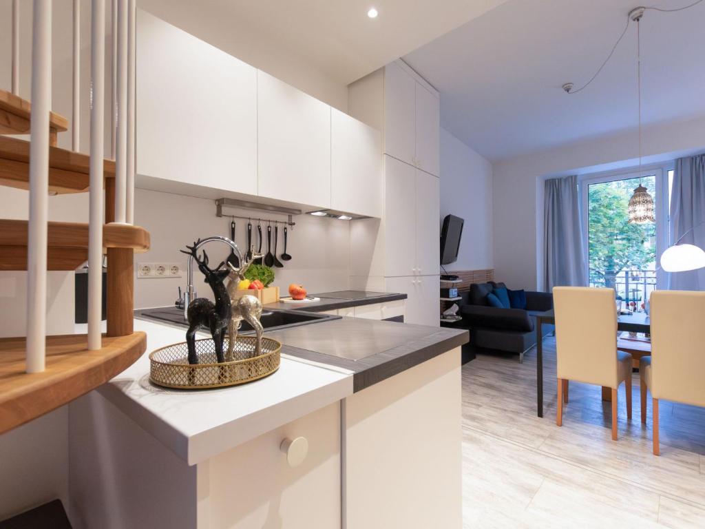 une cuisine avec des placards blancs et une salle à manger dans l'établissement Apartment Dr- Adler by Interhome, à Bad Hofgastein