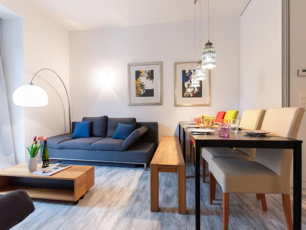a living room with a blue couch and a table at Apartment IVA by Interhome in Bad Hofgastein