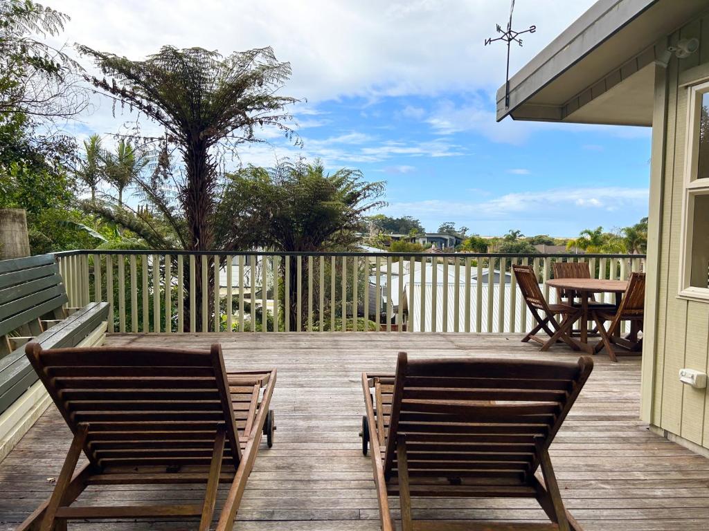 2 chaises et une table sur une terrasse en bois dans l'établissement Princes Retreat, à Ngunguru