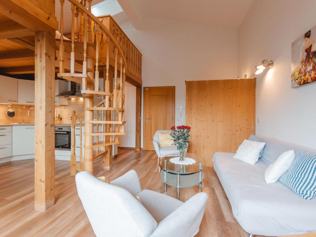 een woonkamer met witte meubels en een wenteltrap bij Apartment Anna-Katharina by Interhome in Bad Hofgastein