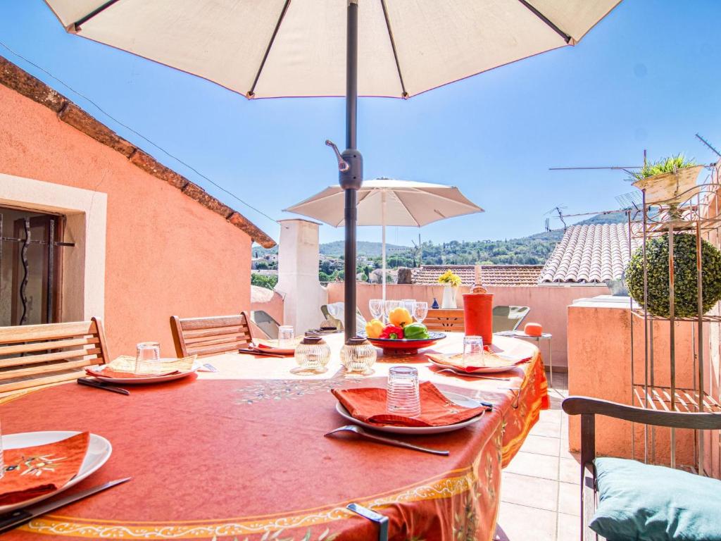 - une table avec des assiettes de nourriture et un parasol sur le balcon dans l'établissement Holiday Home La Roq by Interhome, à Roquebrune-sur Argens