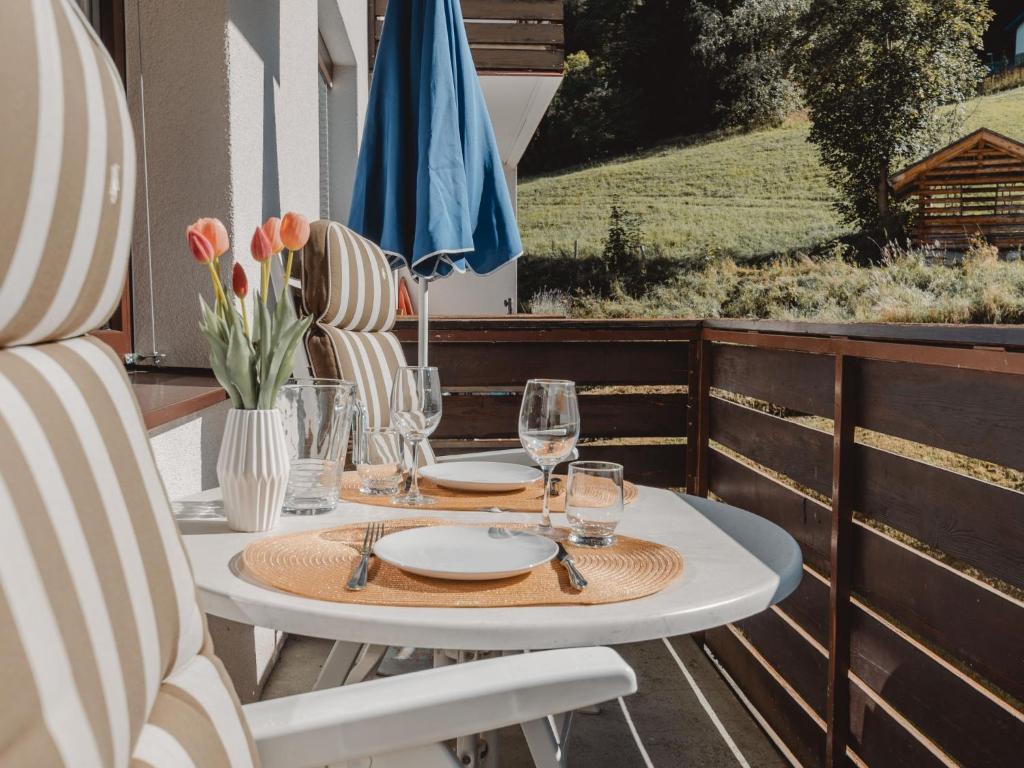 een tafel met borden en glazen op een balkon bij Apartment Murmeltier by Interhome in Bad Gastein