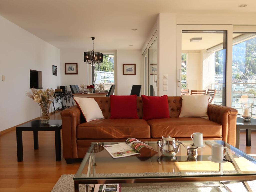 sala de estar con sofá marrón y mesa en Apartment Le Belvédère D3-8 by Interhome en Montreux