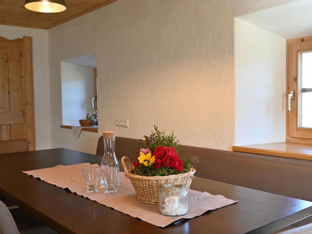 a table with a basket of flowers and glasses on it at Apartment Appartment Wiesberg by Interhome in Niedernsill