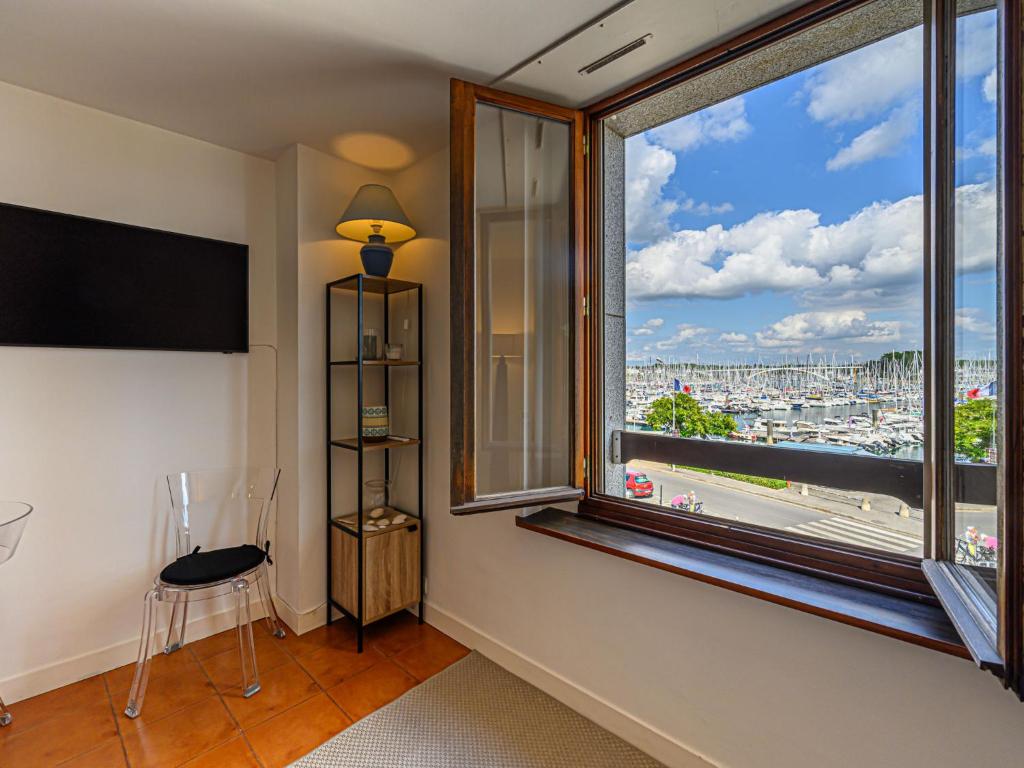 a room with a large window with a view of a city at Apartment Le Quai by Interhome in La Trinité-sur-Mer