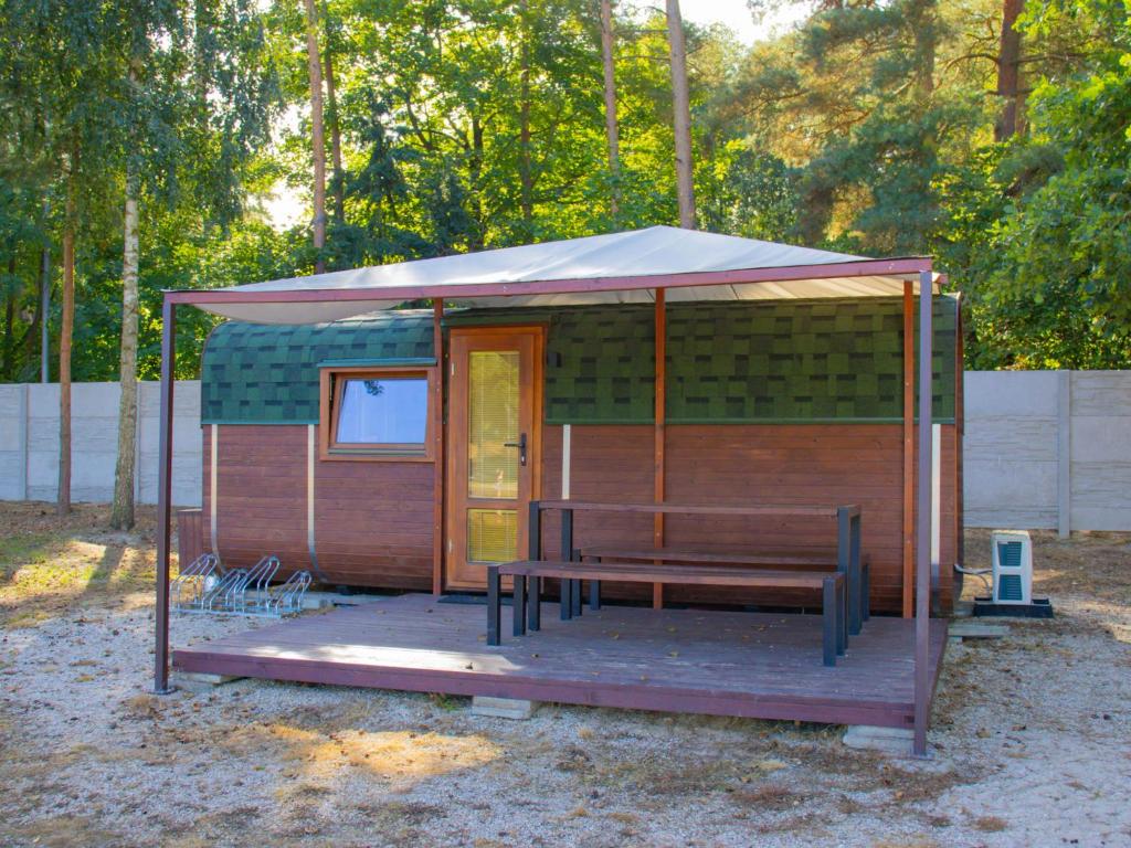 eine kleine Hütte mit einem Zelt und einer Bank in der Unterkunft Holiday Home Kemp Stříbrný rybník-10 by Interhome in Hradec Králové