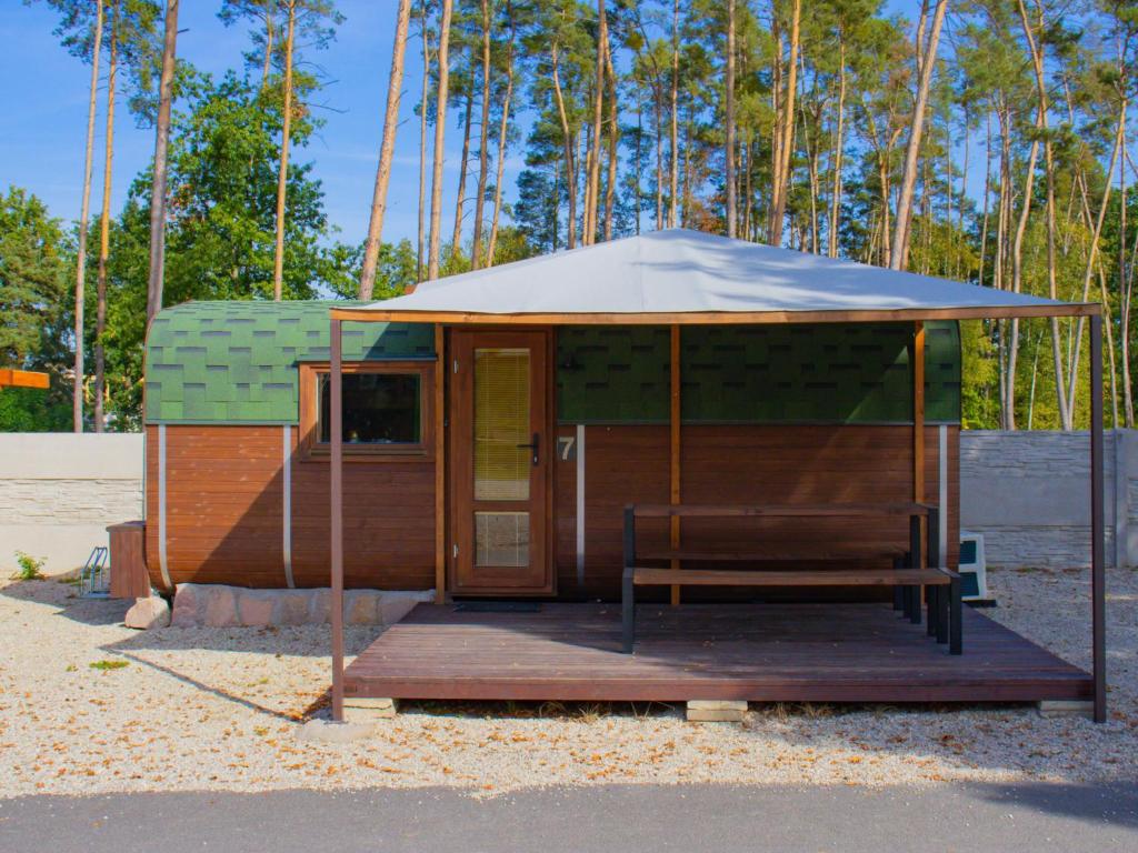 a tiny house with a roof and a porch at Holiday Home Kemp Stříbrný rybník-7 by Interhome in Hradec Králové