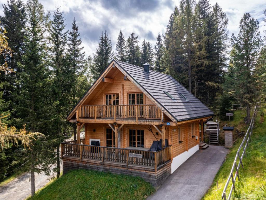 uma cabana de madeira com um alpendre e um deque em Chalet Schwabenhütte by Interhome em Sirnitz-Sonnseite