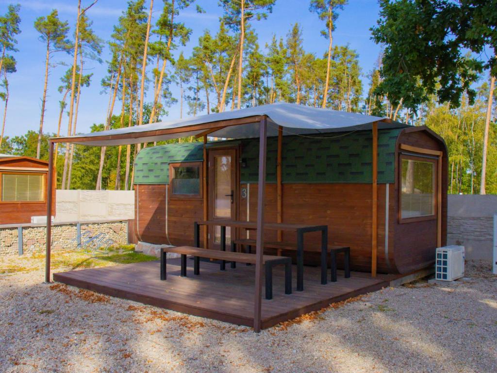 eine kleine Hütte mit einem Tisch und einem Zelt in der Unterkunft Holiday Home Kemp Stříbrný rybník-3 by Interhome in Hradec Králové