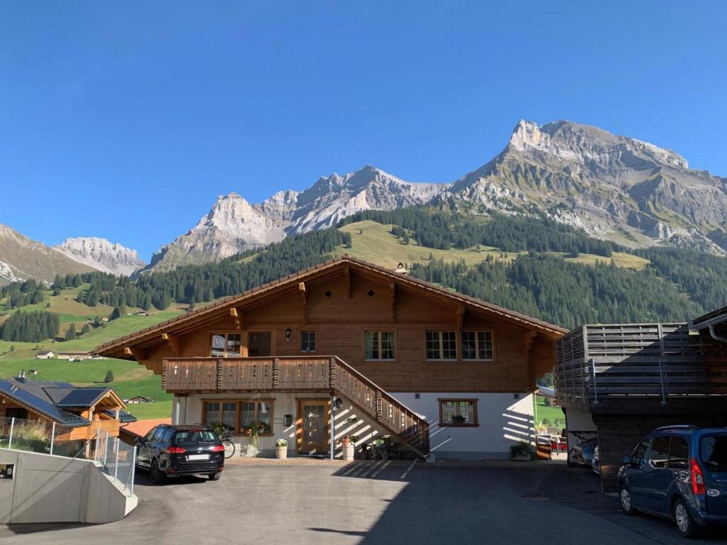 a large wooden building with mountains in the background at Apartment Uf dr Fuhre by Interhome in Adelboden