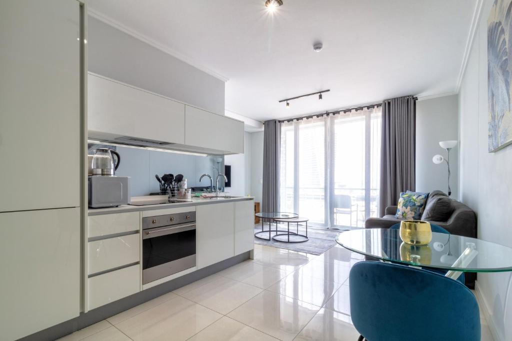 a kitchen and dining room with a glass table at AlimamaSpaces The Moksit Suite Ellipse in Midrand