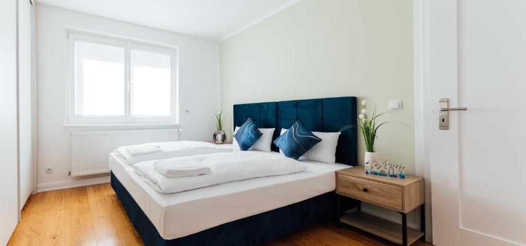 a bedroom with a large bed with a blue headboard at Hanseat Apartments in Hamburg