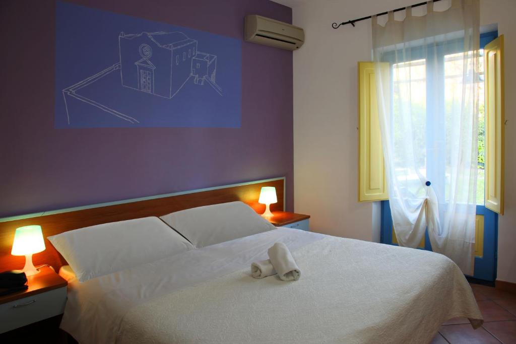 a bedroom with a white bed with a pair of shoes on it at Solcalante in Procida