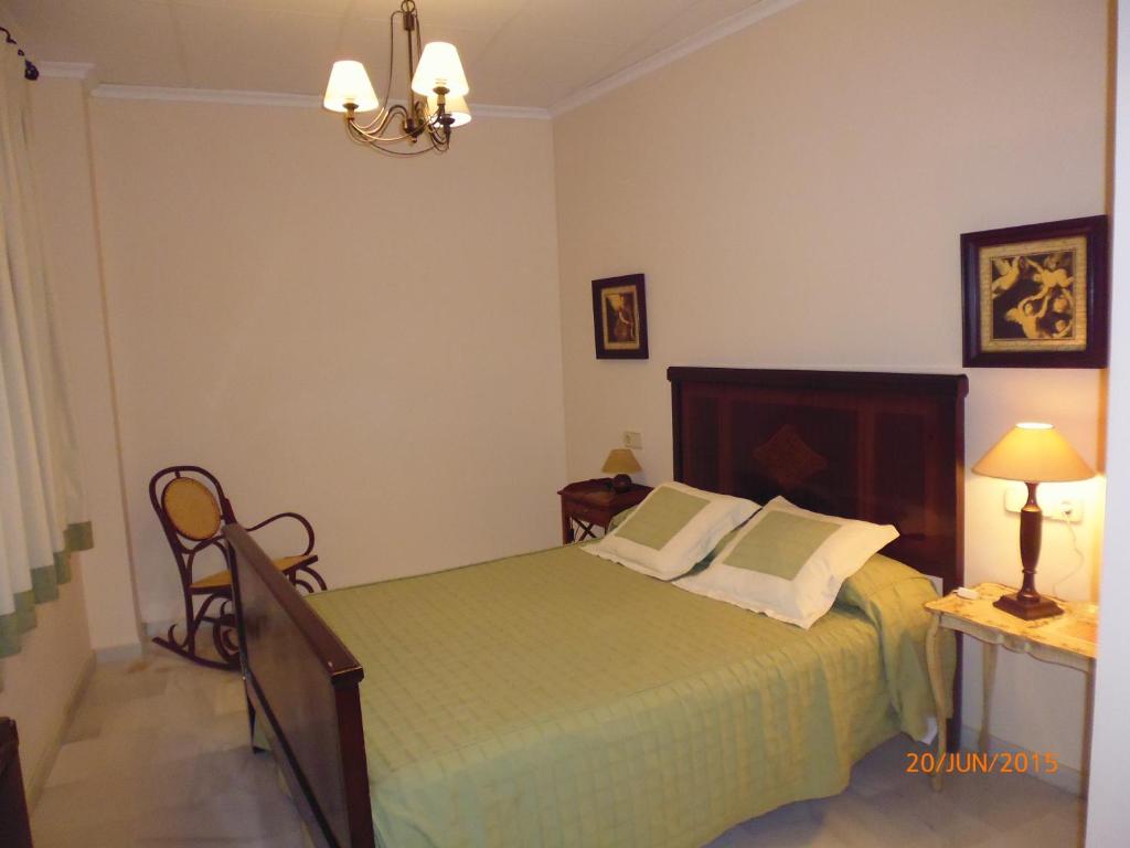 Un dormitorio con una cama verde y una lámpara en Hostal Artiga, en Alborea