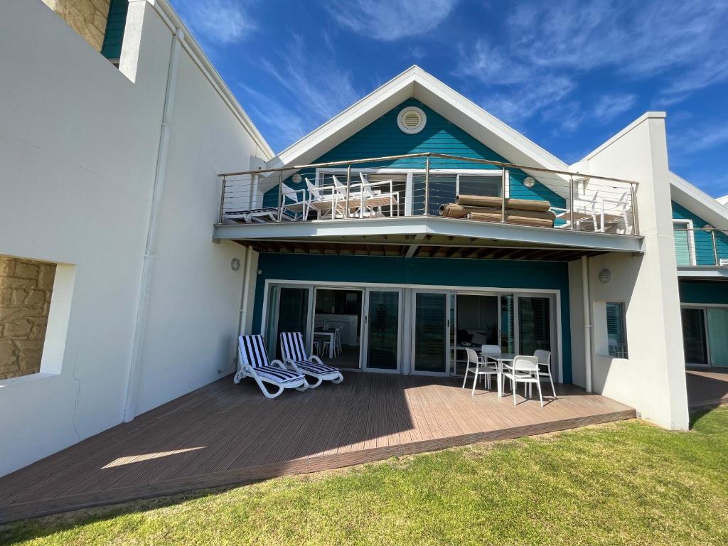 a house with a deck with chairs and a balcony at Beachside Villa 7.1 in Mandurah