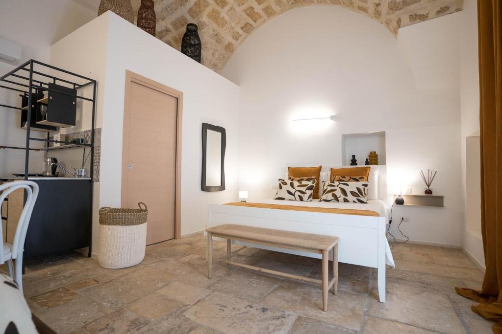 a room with a bed with a bench and a table at IMMA APULIA APARTMENTS in Bari