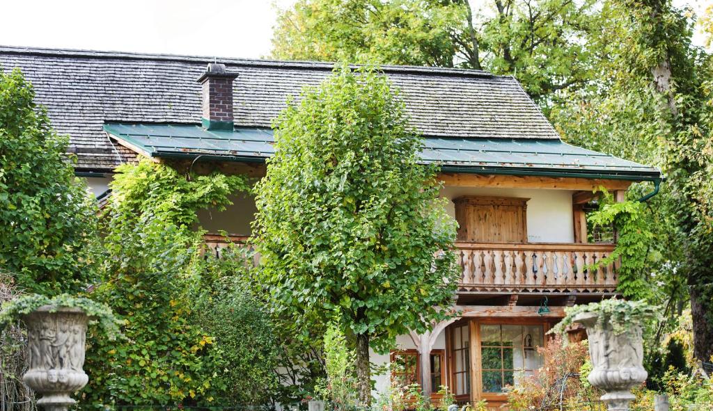 an old house with a balcony and trees at Garden Cottage der Villa Liechtenstein in Altaussee