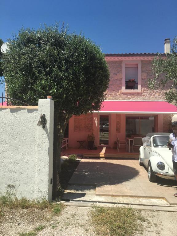 un coche blanco estacionado frente a una casa en La Coccinelle, en Nimes