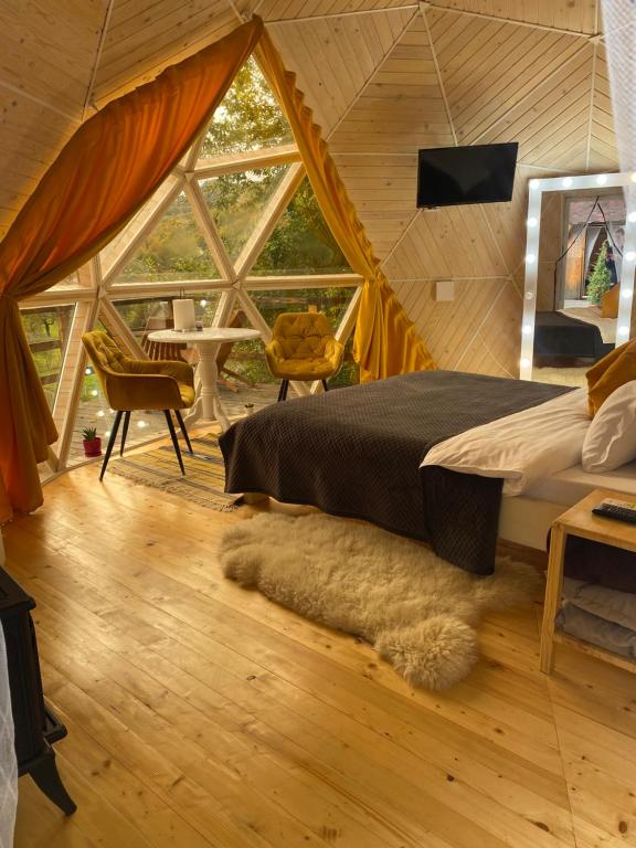 sypialnia z łóżkiem i dużym oknem w obiekcie Honey dome w mieście Vizhenka