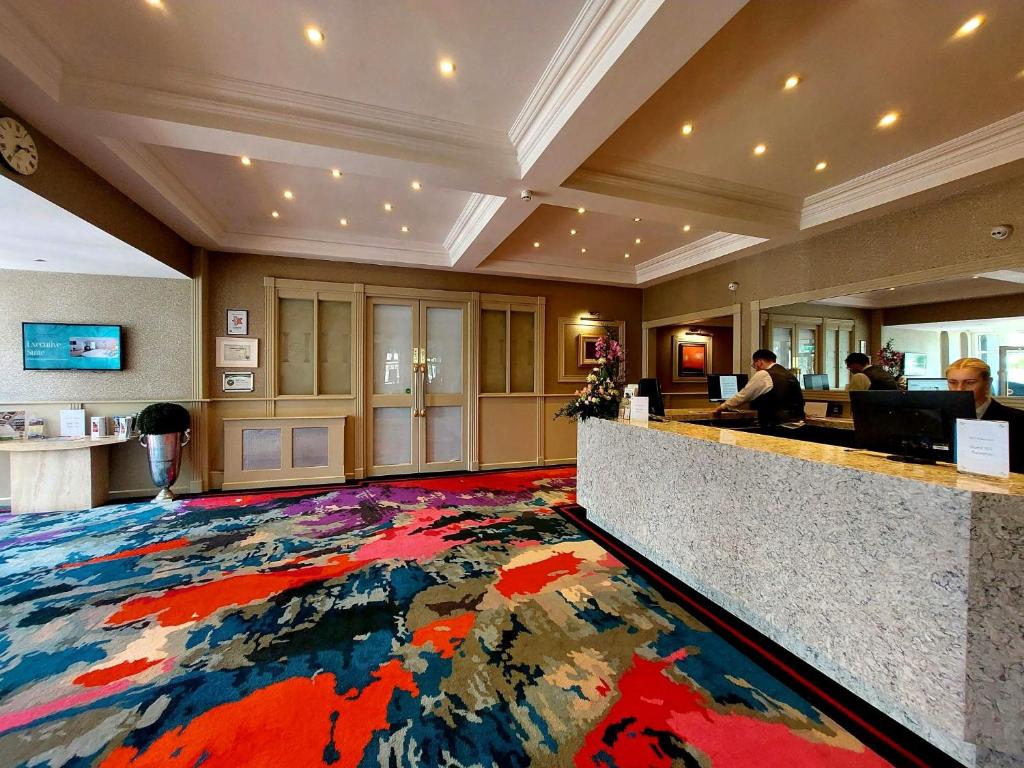 a lobby with a large colorful rug on the floor at Flannery's Hotel in Galway