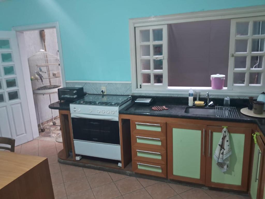 uma cozinha com um fogão e uma bancada em dormitorio 4 solteiro luxuoso a 2 km de alphaville em Barueri