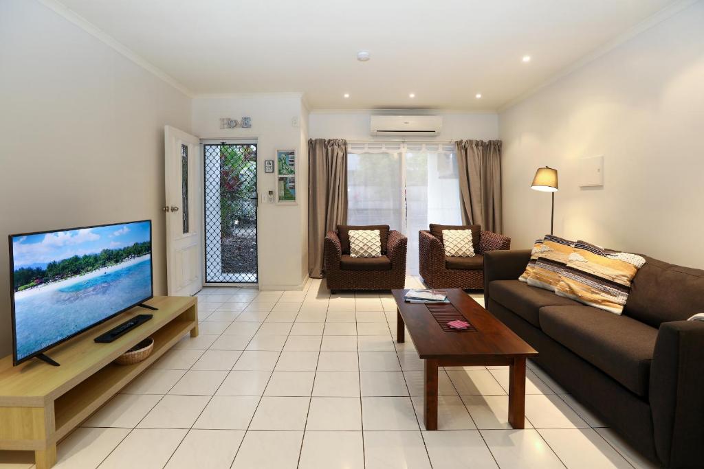 uma sala de estar com um sofá e uma televisão de ecrã plano em 1 Bed Apartment Close to the Beach and Town em Port Douglas