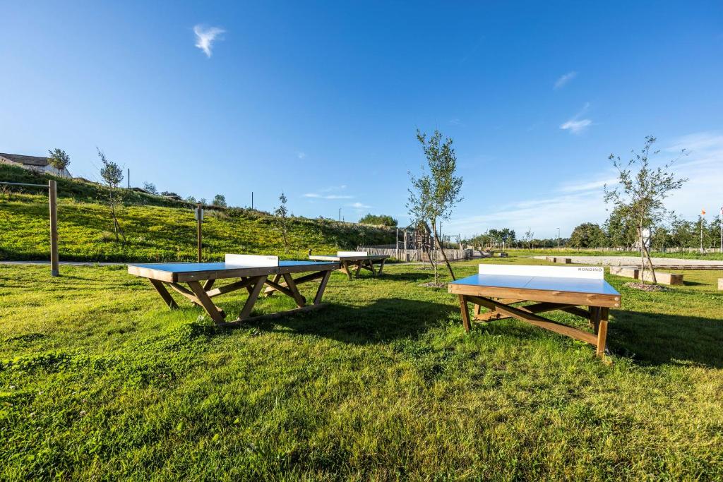 a group of picnic tables sitting in the grass at DOMAINE SAÂNE ET MER in Quiberville