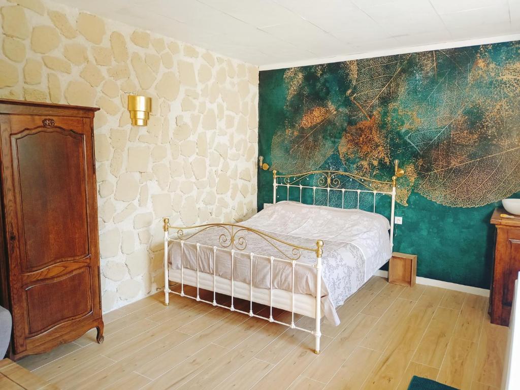 1 dormitorio con 1 cama y una pintura en la pared en Bulles de Lune, en Sacy