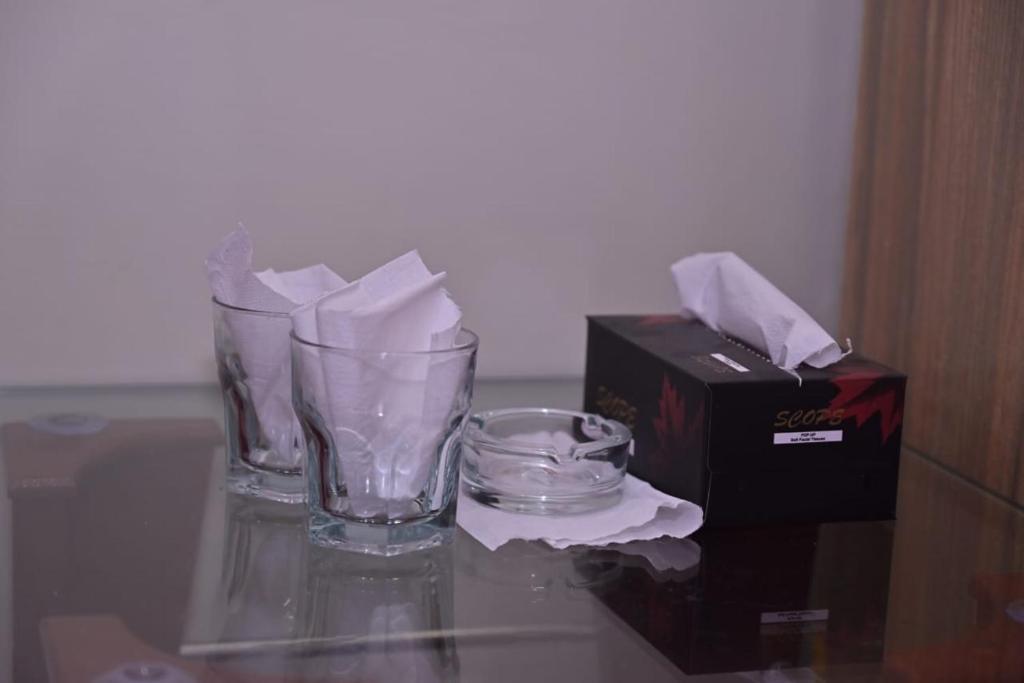 een glazen vaas en een doos op een glazen tafel bij Hotel Royal Galaxy in Lahore
